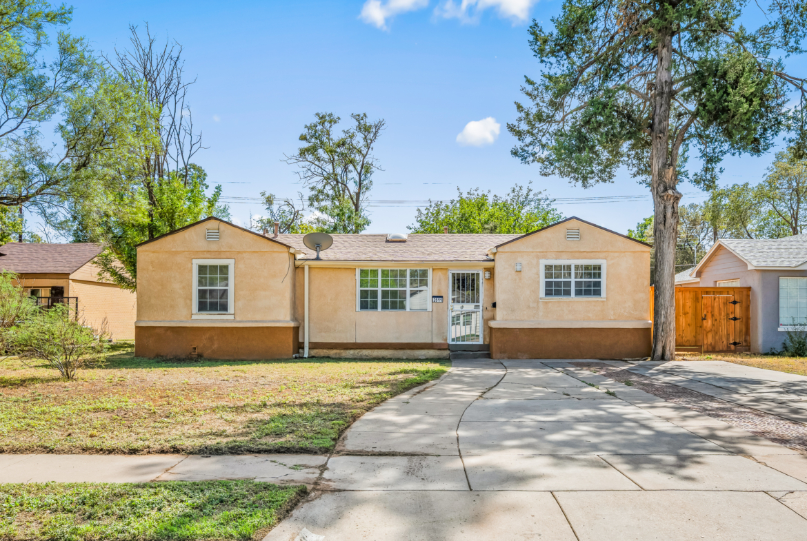 Lubbock Lease Homes: A single-story tan house with a concrete driveway and a front yard.
