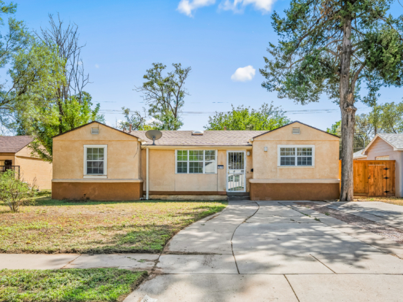 Lubbock Lease Homes: A single-story tan house with a concrete driveway and a front yard.