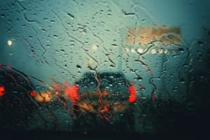 Lubbock Lease Homes: Raindrops cover a car windshield, blurring traffic lights and taillights into red and yellow hues. It evokes a moody, rainy night—perfect for reflecting on tips for moving to Lubbock as you navigate the city’s wet streets.